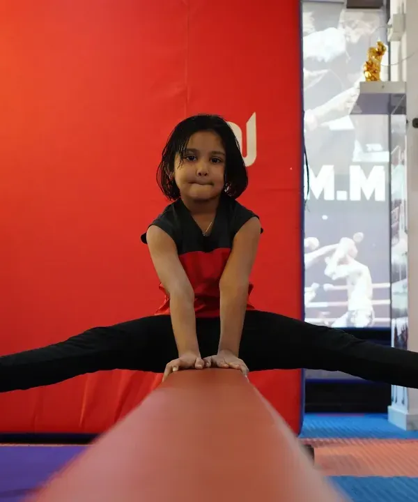 A young gymnast demonstrates her focus and flexibility with a perfect center split on the balance beam. We build confidence from day one, helping kids achieve goals they can be proud of.