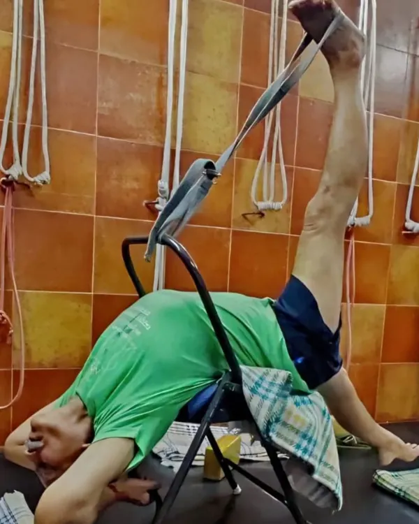 A demonstration of a supported leg stretch using a chair and strap. This variation of Supta Padangusthasana helps to open the hamstrings while keeping the back stable and supported.