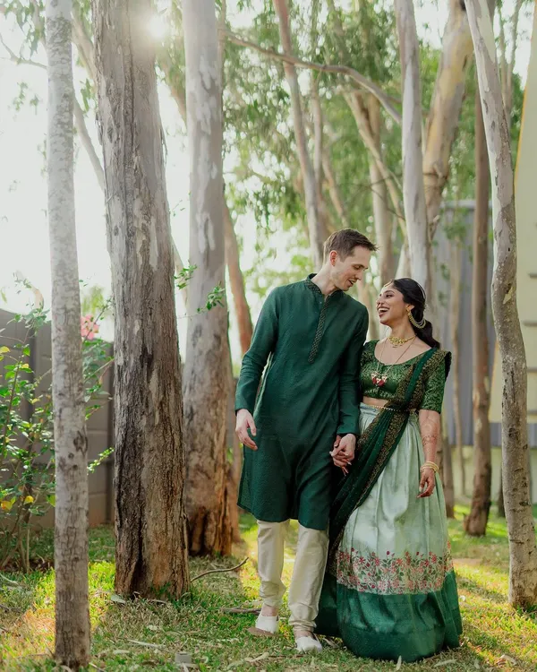 A beautiful portrait of a multicultural couple enjoying a walk in the woods. We love capturing the blend of traditions, like this groom's classic kurta paired with his bride's elegant lehenga.