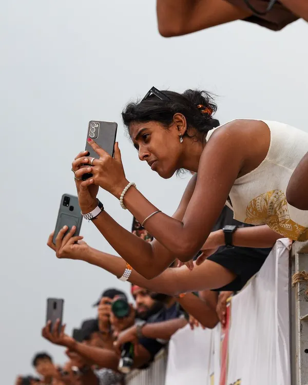 The crowd is as much a part of the show as the cars. Spectators line the rails, phones out, capturing every second of the action. This is the engaged audience your brand can connect with.