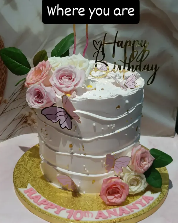 A beautiful floral cake for a 10th birthday. This tall cake features a textured buttercream finish, pink and white sugar roses, and delicate wafer paper butterflies.
