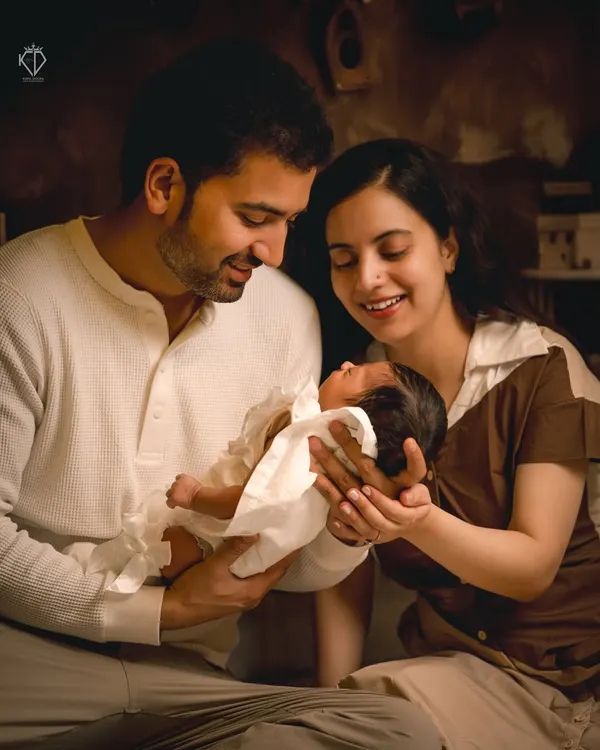 This is the moment I strive to capture. The pure, unscripted connection as new parents hold their entire world in their hands. I used soft, warm lighting to create an intimate atmosphere for this indoor family portrait.