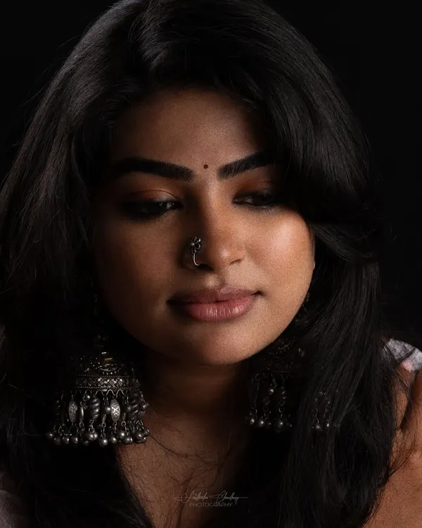 A moody studio portrait where the makeup is key. I used a soft, smoky eye and a nude lip to create a look that is both gentle and striking against the dark background.