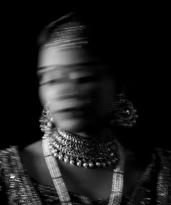 An abstract and artistic bridal portrait using motion blur. In black and white, this technique creates a ghostly and ethereal image, focusing on the form and jewelry of the bride.