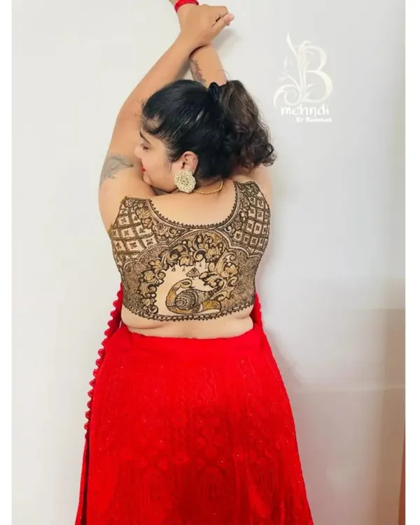 A creative pose showing off the beautiful peacock and jaal pattern mehndi I created to look like a blouse design.