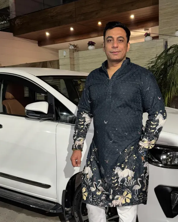 A client looking stylish in a custom-printed black kurta. The unique design featuring horses and birds adds an artistic touch to this traditional garment, making it perfect for a festive occasion.