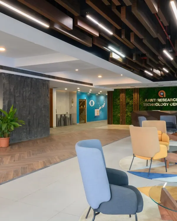 This is what I mean by making an entrance. For the Aarti Research & Technology Center, I wanted to create a lobby that felt dynamic and alive. We combined a custom faceted reception desk with a lush moss wall for branding, and used a mix of wood and stone flooring to guide visitors through the space.
