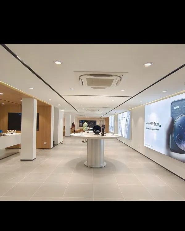 The completed interior of a retail showroom for a leading tech brand. The design features clean lines, bright lighting, and uncluttered displays to focus attention on the products.
