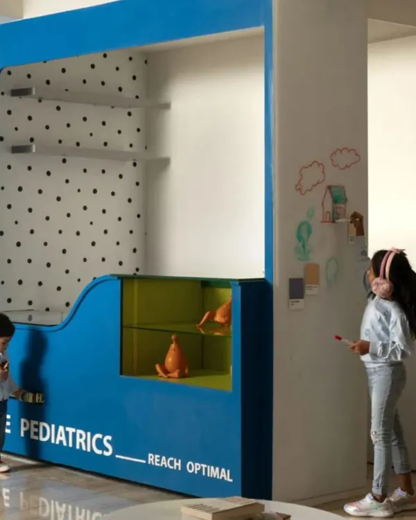 The centerpiece of the clinic's waiting area is this interactive "Plug & Play" unit. It provides a space for children to feel comfortable and engaged, with a whiteboard wall for creative expression.