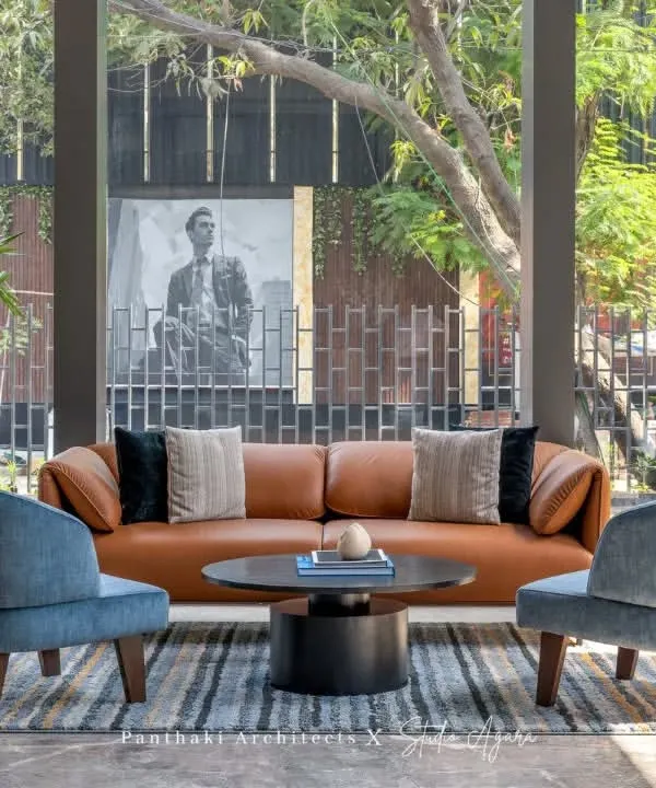 We designed this sales office lounge in Malad to be bathed in natural light. The comfortable leather sofa and modern armchairs create a relaxed yet sophisticated atmosphere for welcoming clients.