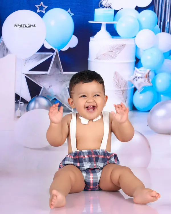 The pure, unfiltered joy of a first birthday cake smash. This little boy's happy expression and messy hands perfectly capture the fun of this milestone celebration.