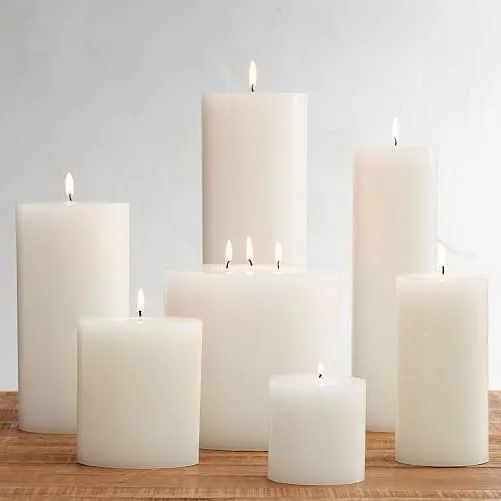 A collection of my handmade ivory pillar candles, lit to create a warm and inviting glow. This shows how you can group different sizes, from small to large, to create a stunning centerpiece for any event or a cozy corner in your home.
