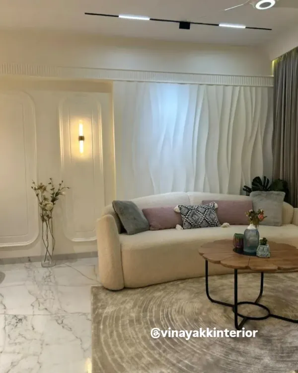 I believe in creating living rooms that are both serene and stylish. This space uses a soft, neutral palette, a plush curved sofa, and elegant 3D wall paneling to create a minimalist yet luxurious feel. The design focuses on texture and light to make the room feel warm and inviting.