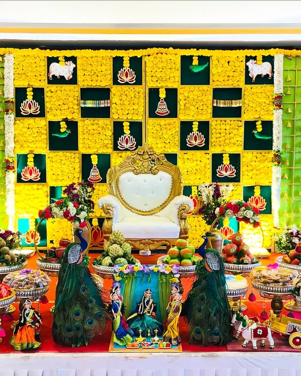 This is the kind of grand, traditional setup I love to create for a Seemantham or baby shower. The vibrant yellow and green flower wall, with auspicious motifs like the lotus and cow, creates a perfect backdrop for the main ceremony chair, all surrounded by my signature plate decorations.