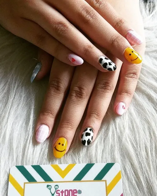 This mismatched set is all about fun. I hand-painted smiley faces, cow print, a pink checkered pattern, and tiny hearts to create a playful and happy vibe on these rounded nails.