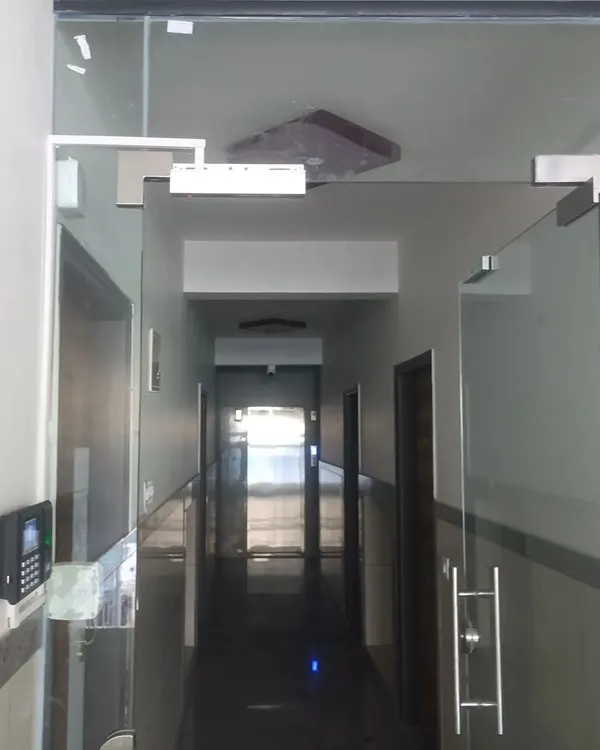 A complete access control installation for a modern office with glass doors. This system features a wall-mounted eSSL biometric reader for secure entry and an electromagnetic lock, providing a clean and effective security solution for corporate environments.