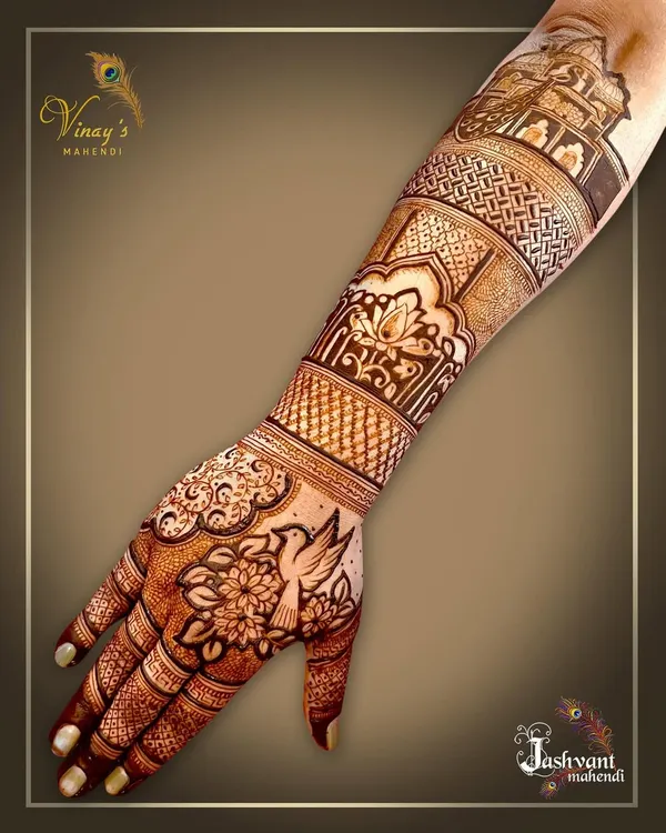 A delicate back-hand design featuring a bird surrounded by flowers. The pattern extends up the arm with architectural and floral bands.