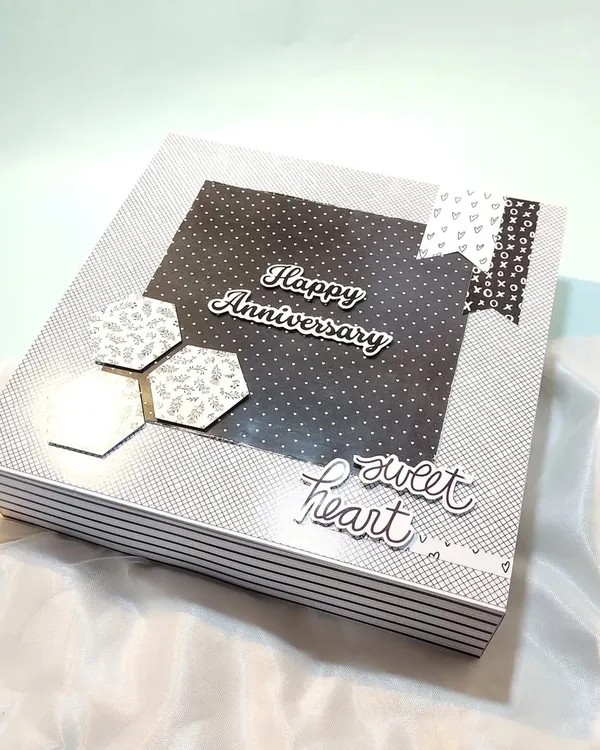 The cover of a stylish black and white anniversary gift box, which can be filled with a scrapbook and other goodies for him.