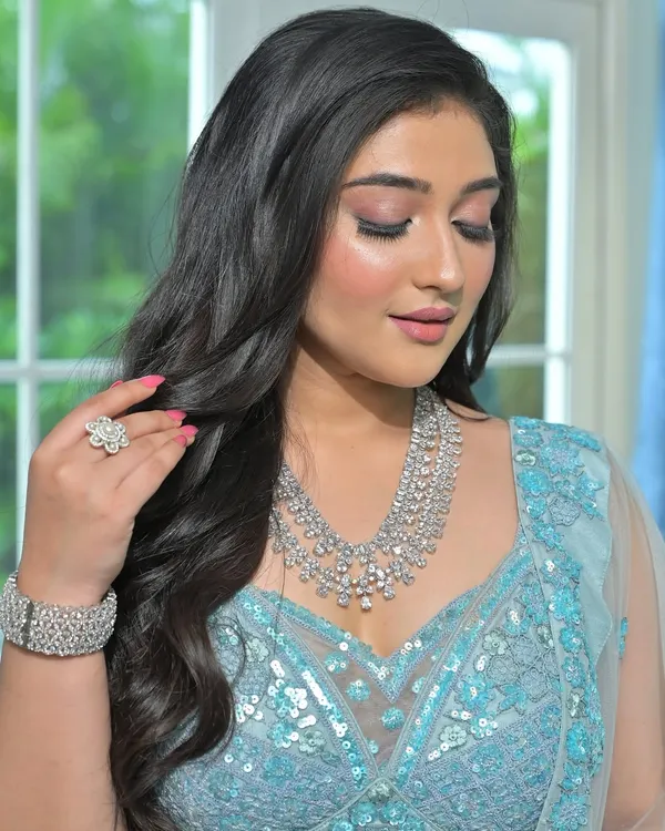 An ethereal look for a modern reception. This bride is wearing a stunning multi-layered diamond-look necklace with a matching bracelet and ring, paired with a sequined light blue lehenga.