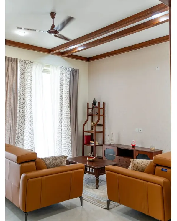 This living room is a symphony of textures and tones. The warm tan leather sofas, custom solid wood furniture, and elegant ceiling rafters create an intimate and luxurious space, perfect for welcoming guests or enjoying a quiet evening.