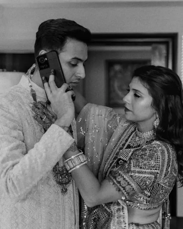 Even in the middle of wedding day chaos, a groom needs to look sharp. This candid shot captures a real moment while showing off the groom's elegant sherwani. My job is to make sure every detail is perfect, even when they're on an important call!