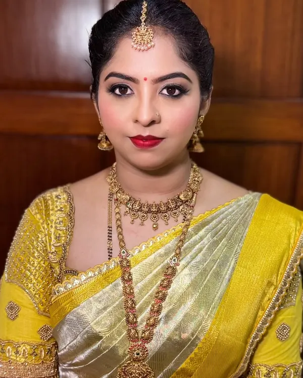 A close up of Ashritha's wedding day makeup. The look features a classic winged eyeliner, a bold red lip, and glowing skin, perfect for a traditional Kannada bride.