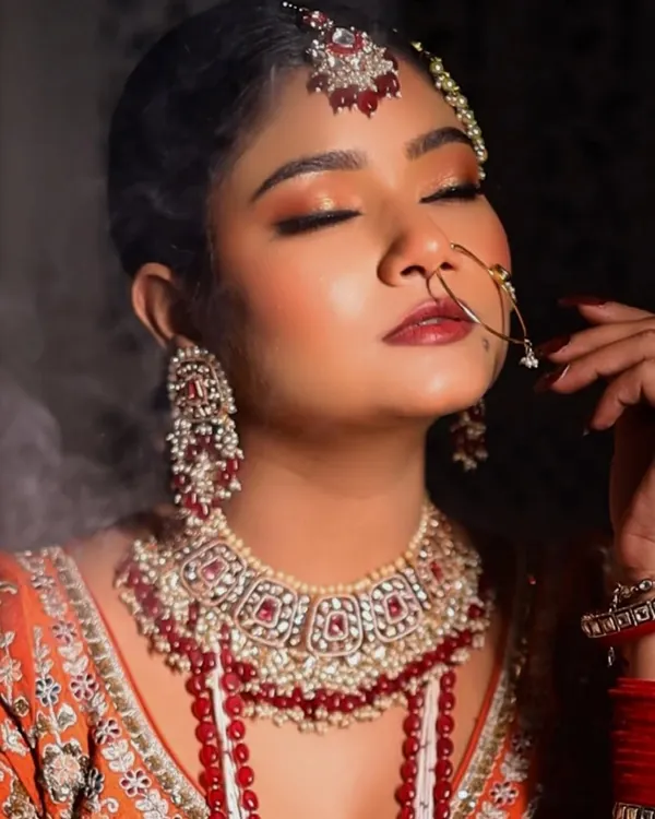 A close-up of a full glam Nikkah look, with eyes closed to showcase the soft, peachy-golden glittery eyeshadow. The look is dramatic yet elegant, perfect for a bride.