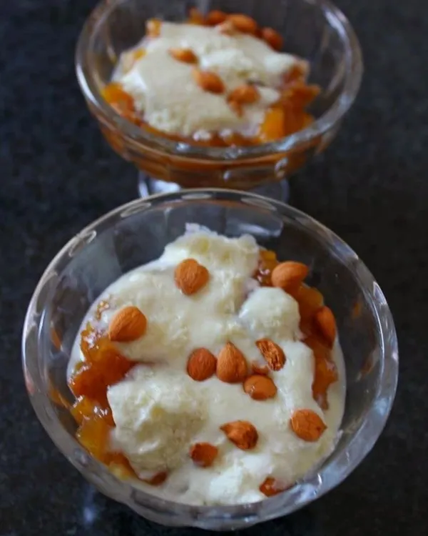 Our famous Apricot Delight, also known as Khubani ka Meetha. This Hyderabadi dessert features stewed apricots topped with fresh cream or custard and garnished with almonds, offering a perfect balance of sweet and tangy flavors.
