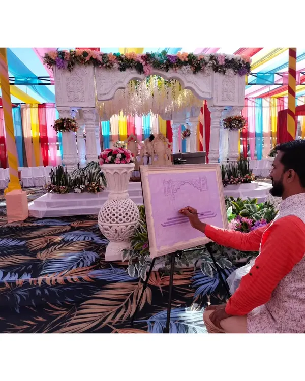 Here I am during the process of a live wedding painting. I set up my easel at the venue and paint the scene as it unfolds, capturing the vibrant atmosphere of the ceremony.