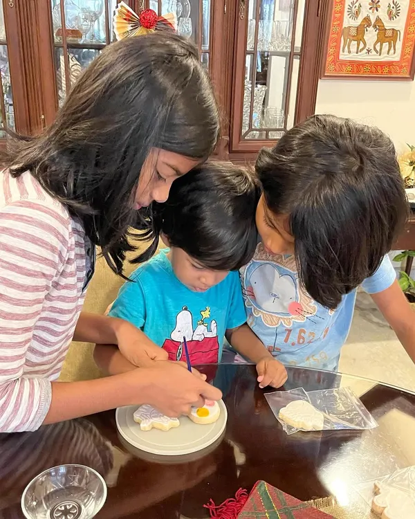 It's so lovely to see siblings getting creative together. This little one is getting some help from his big sisters to paint his cookie. It’s a perfect, screen-free activity for the whole family to enjoy.
