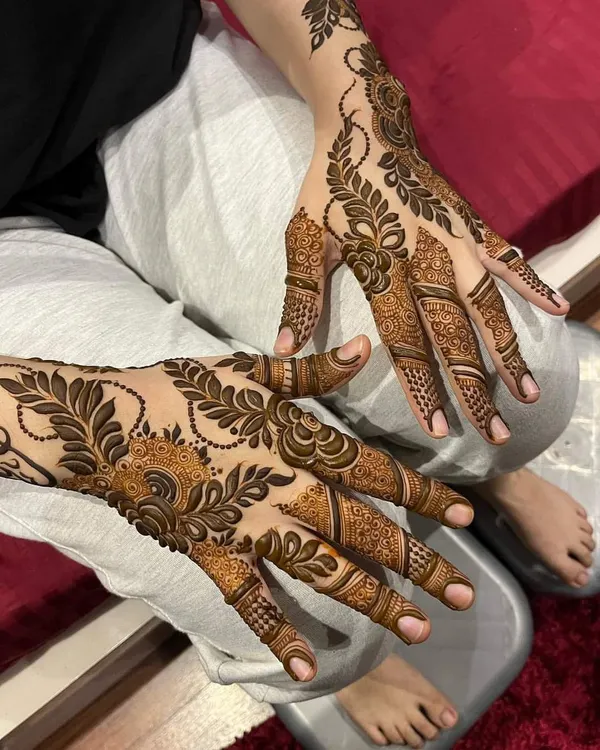 A beautiful example of a modern Arabic fusion design, featuring bold leafy vines and delicate filler patterns that flow elegantly across the hands.