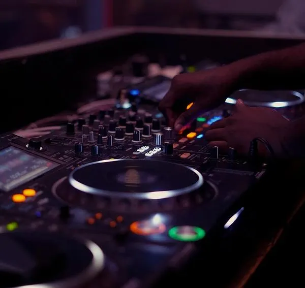A close-up of my hands adjusting the levels on the mixer. This is where I fine-tune the sound, ensuring every element of the track is perfectly balanced.