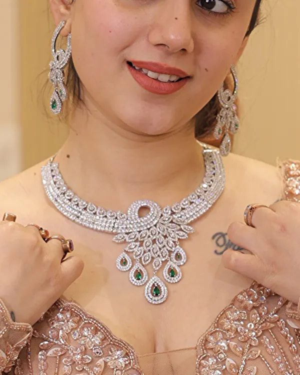 A stunning diamond-look necklace with emerald and ruby drops, paired with a sequin blouse. This shows how our jewelry can elevate any modern or cocktail outfit.