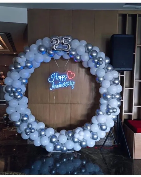 Celebrating a silver jubilee is a huge milestone. For this 25th anniversary, I created a large balloon ring in silver and white, with a "Happy Anniversary" neon sign at the center to serve as a perfect photo spot for the happy couple.