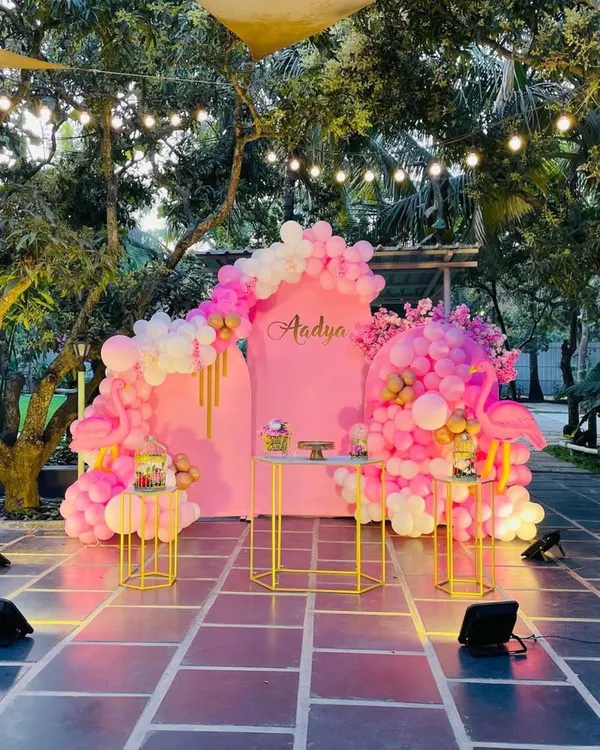 I created this beautiful flamingo-themed party for a special birthday. The outdoor setting at dusk was perfect for the pink and white organic balloon garlands, complemented by string lights to create a magical atmosphere. This setup is ideal for garden or terrace parties.