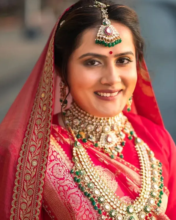 A close-up of this royal and elegant bride. Her makeup features soft, defined eyes and a natural lip color, allowing her stunning traditional jewelry to shine. This look is all about creating a regal yet authentic bridal appearance.