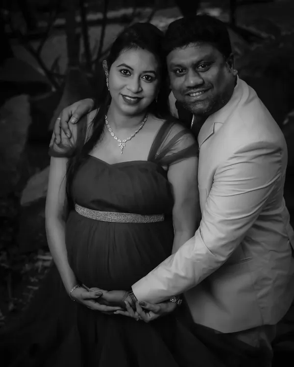 A classic black-and-white couple's portrait. This timeless style emphasizes their expressions and the protective way they hold the baby bump, creating a powerful, emotional photo.