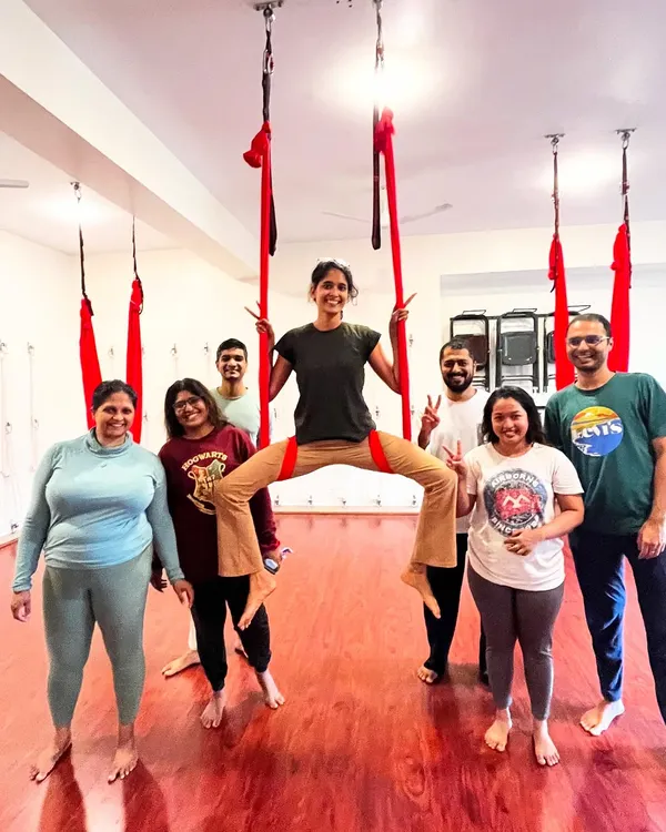 The smiles say it all! This is a typical moment from one of my adult aerial yoga classes, full of fun, strength, and great energy. I'm in the middle, guiding the group through a playful pose.