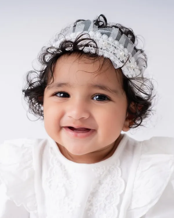 A close up of a happy sitter. At this age, their expressions are priceless. This little girl's smile and bright eyes show the pure joy of a 7 month old baby, which I love to capture.