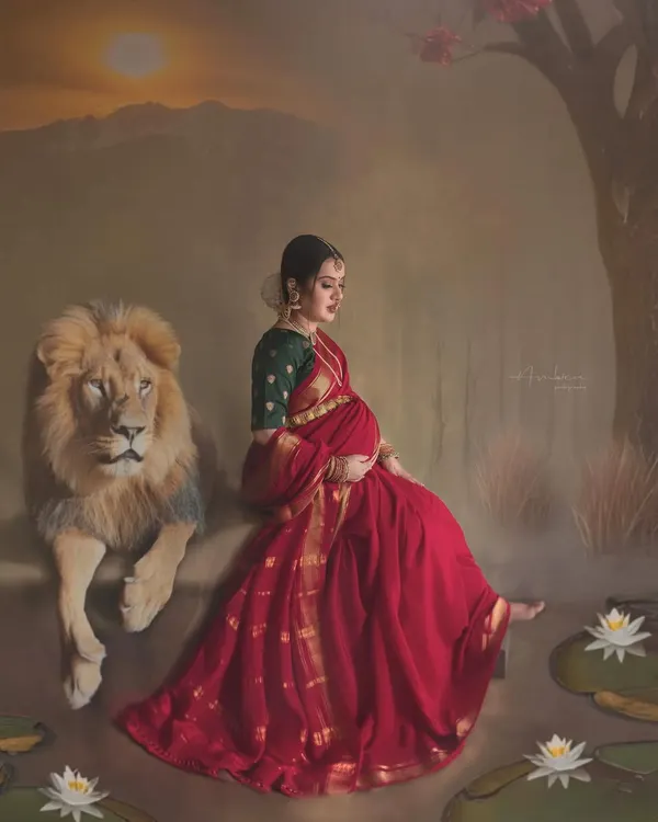 Inspired by the goddesses of Indian folklore, this conceptual maternity portrait captures the quiet strength and fierce love of a mother. The composition, with the mother in a traditional red saree seated beside a lion, creates a powerful, painterly image of feminine power.