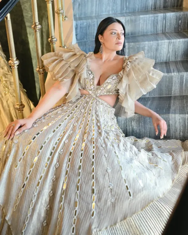 A full view of this magnificent couture gown, showcasing its tiered structure and intricate metallic detailing. When styling for a major event, the goal is to choose a piece that not only looks stunning but also photographs beautifully from every angle.