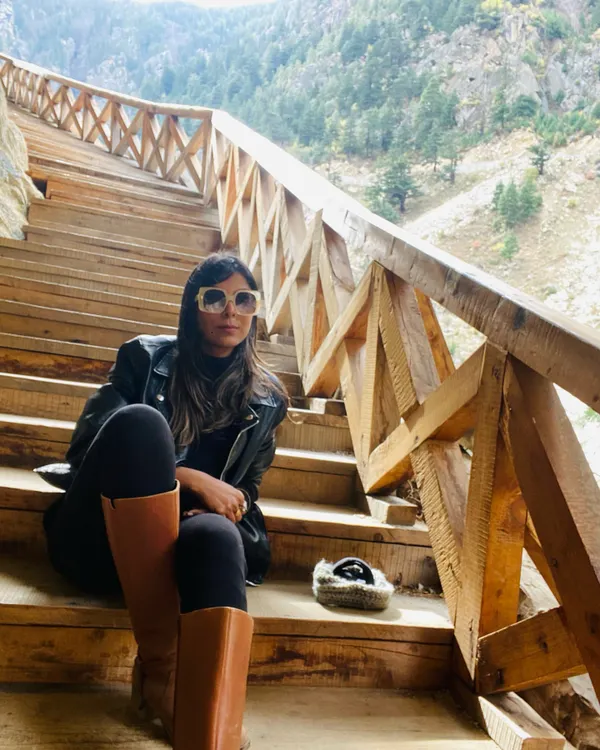 Hello winters. A classic winter travel look with a black leather jacket, black leggings, and tall brown boots. This outfit is perfect for exploring a chilly mountain destination in style.