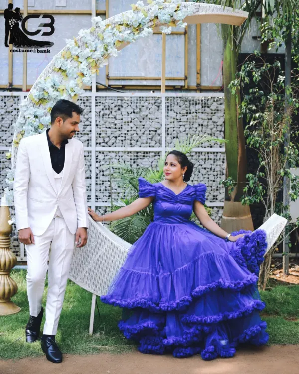 A fairytale pre-wedding moment captured with a stunning royal blue ruffled gown and a sharp white tuxedo, complete with a whimsical moon prop for a magical touch.