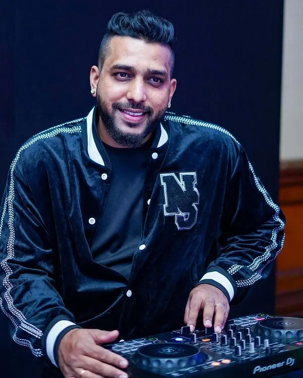 A candid shot of me at the console. I'm not just playing music; I'm focused on crafting a seamless experience for the audience.