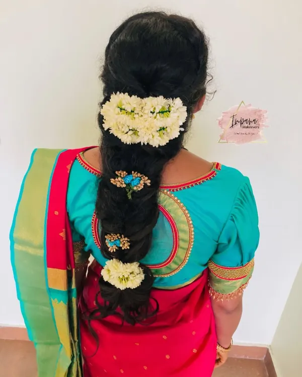 A beautiful messy braid for a housewarming ceremony. This hairstyle combines traditional elements with a modern twist, using fresh flowers and decorative pins for an elegant finish.
