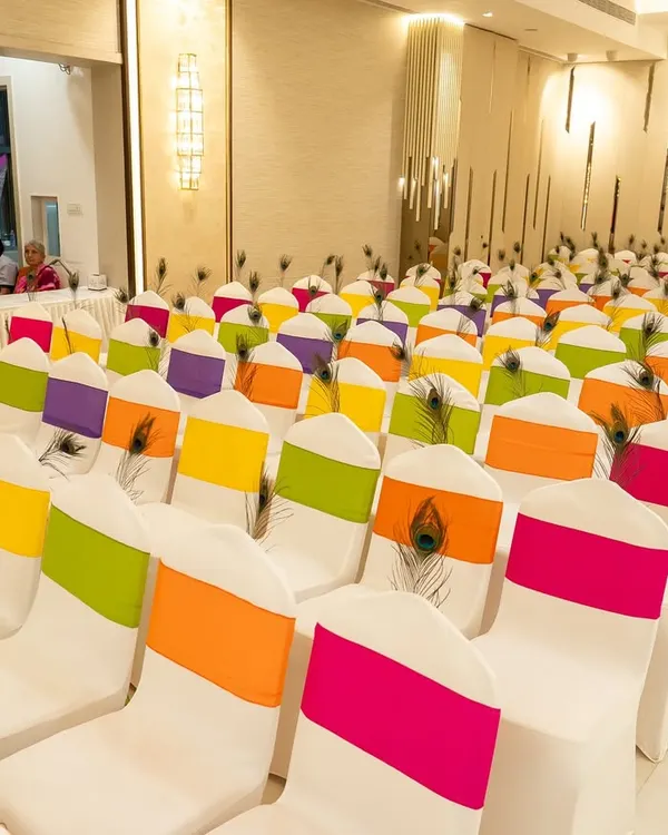 For a Radha Krishna themed Garba night, I used peacock feathers and vibrant, colorful sashes on the chairs to bring the theme to life throughout the venue.