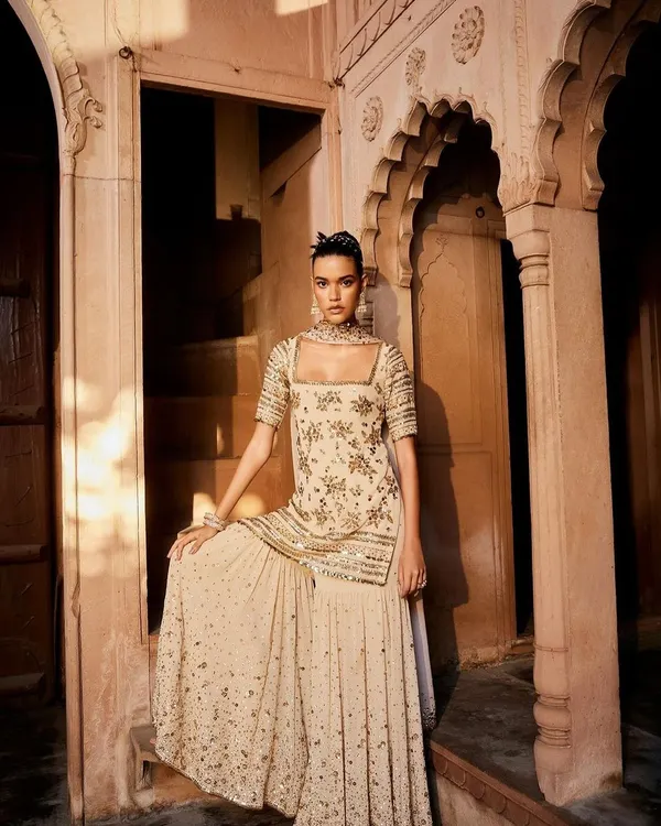 A sharara set that feels like a dream. The intricate sequin work on this beige ensemble creates a look of pure, understated glamour, perfect for a festive evening.