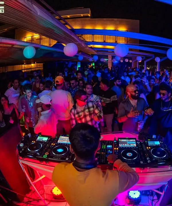 This is what it's all about. Me, the music, and a sea of happy faces on a rooftop overlooking the city. I live for moments like this, connecting with the crowd and creating a vibe that's pure magic.