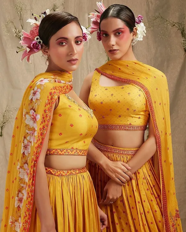A high-fashion, artistic look perfect for a themed sangeet or a creative pre-wedding shoot. The bold, colorful blush and fresh flowers in the hair create a memorable and unique bridal statement.