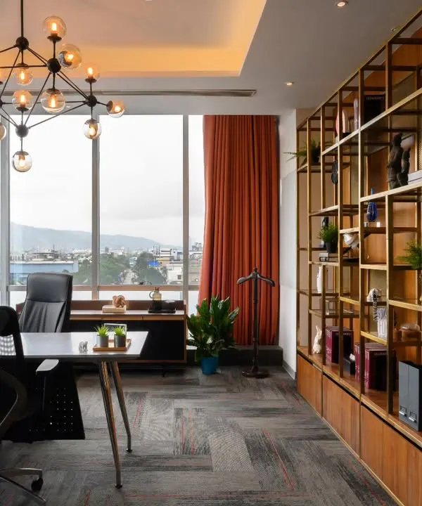 This key personnel cabin is all about balancing function with a sense of grandeur. The large desk provides ample workspace, while the custom shelving and dramatic chandelier add personality. The large windows frame the city view beautifully.